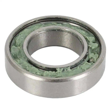 Metal bearing filled with green grease and has a single metal dust shield on a white background